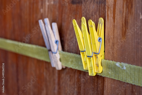 various clothespins in front of a wooden wall