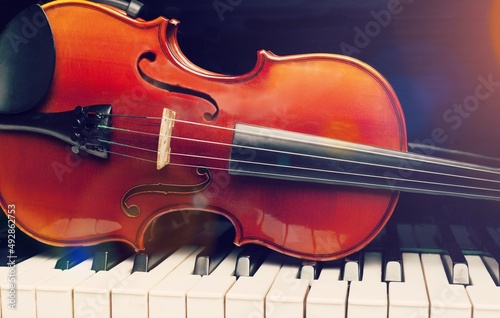 Violin on top of piano keyboard background for music concept