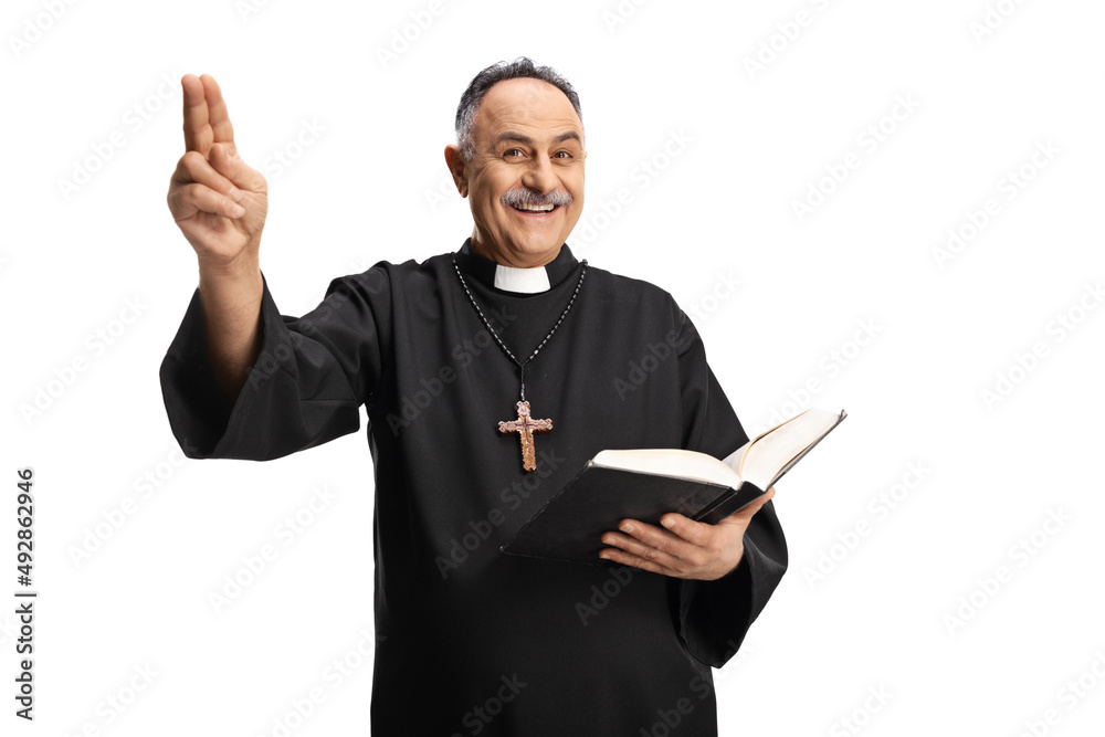 Cheerful priest holding a bible and gesturing with hand Cheerful priest holding a bible and gesturing with hand