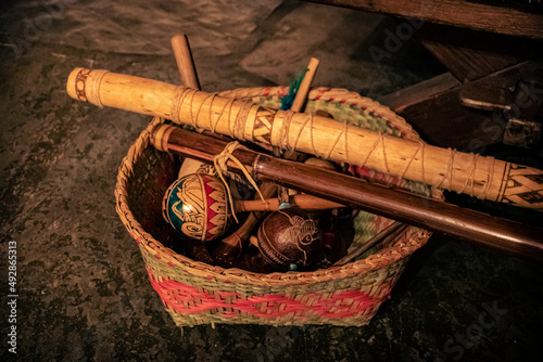 Sao Paulo, SP, Brazil - March 12 2022: Ethnic Guarani basket with Maracá indigenous instruments and flutes detail. photo