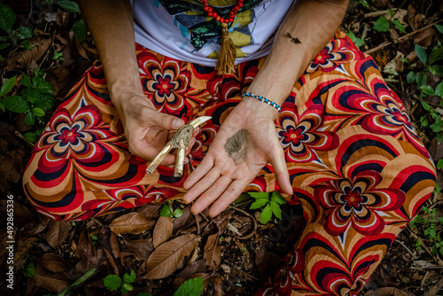 Sao Paulo, SP, Brazil - March 13 2022: Caucasian person hands in colorful clothes holding bone kuripe and snuff details.