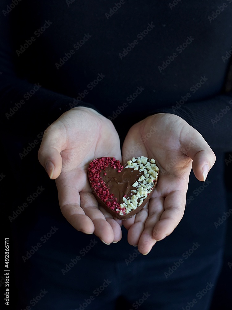 male hand holding a heart of chocolate male hand holding a heart of chocolate