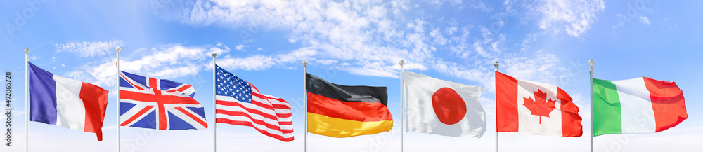 All G7 (Group of Seven) national flags set against blue sky