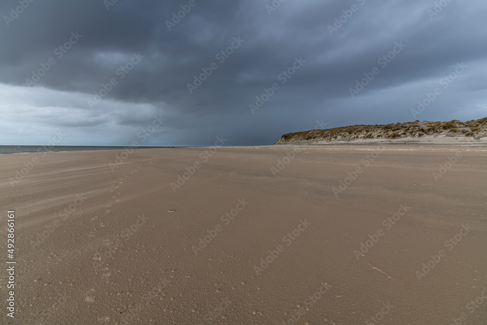 endlose Weite am Sandstrand mit dunklen Regenwolken endlose Weite am Sandstrand mit dunklen Regenwolken
