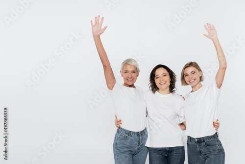 Smiling women in white t-shirts waving hands isolated on grey, feminism concept.