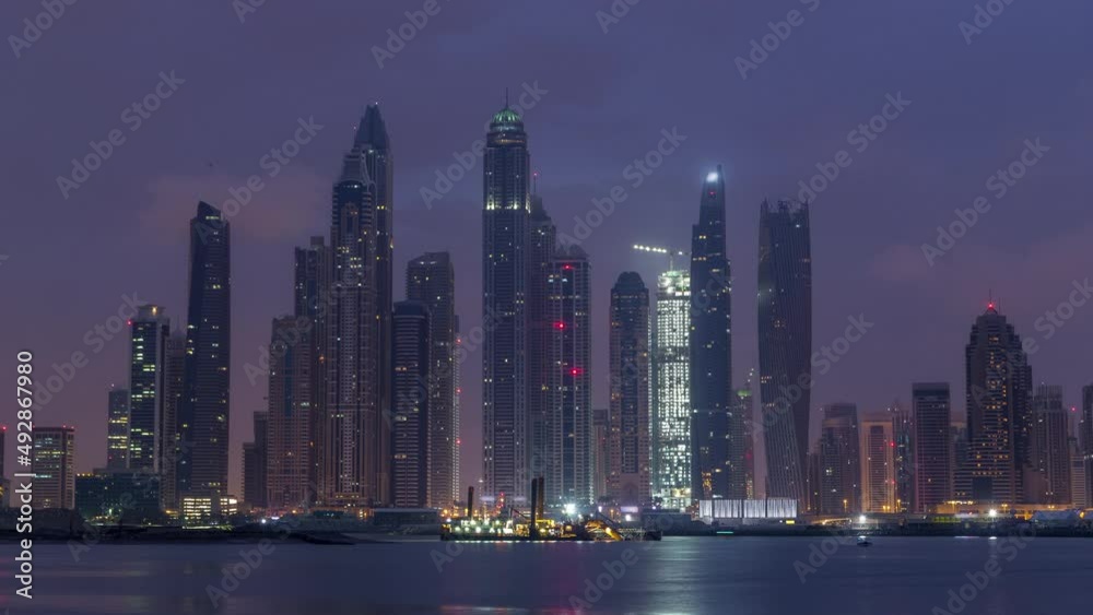 Panorama of modern skyscrapers in Dubai city night to day timelapse from the Palm Jumeirah Island. Panorama of modern skyscrapers in Dubai city night to day timelapse from the Palm Jumeirah Island.