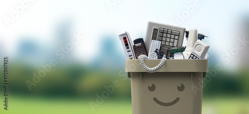 Smiling waste bin full of e-waste photo