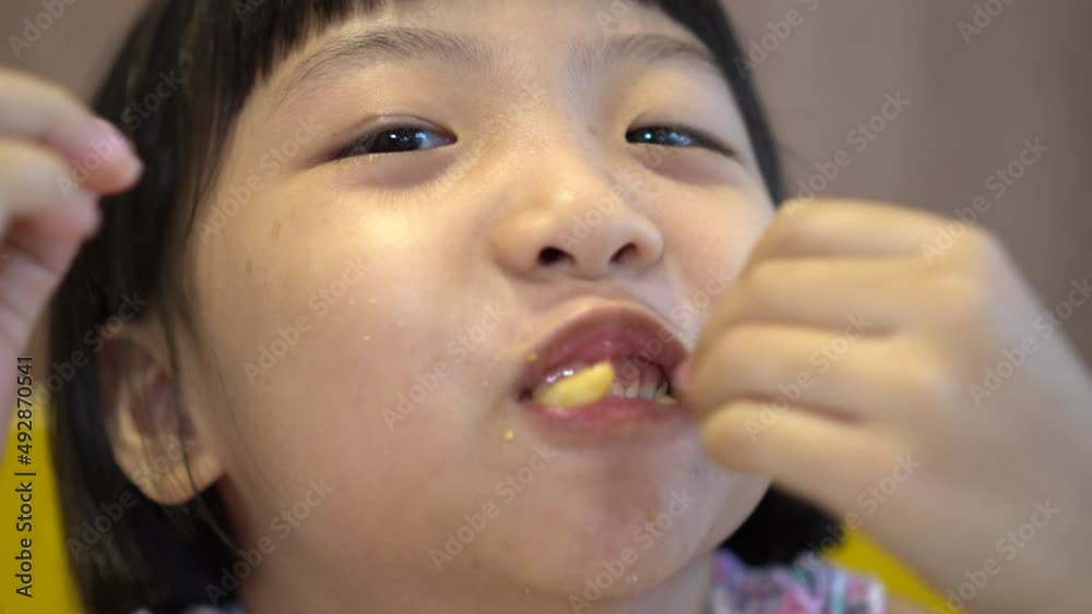 Funny face of chinese girl eat delicious French fries Funny face of chinese girl eat delicious French fries