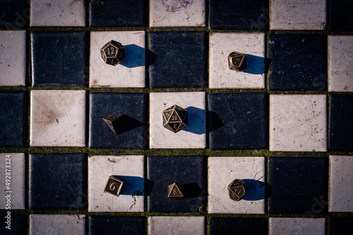 overhead image of a set of roleplaying dice on black and white tiles