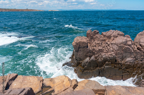 Sea surf day landscape. Sea waves with white foam breaks on stones. Sozopol. Bulgaria