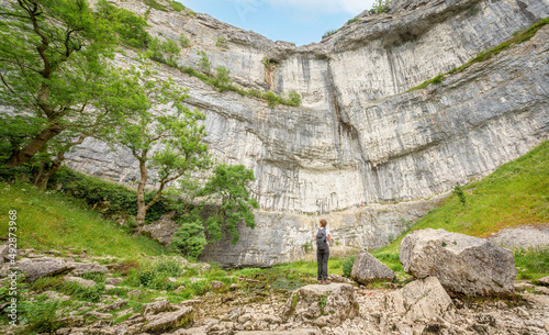 Yorkshire Dales National Park, Yorkshire, UK - March 14, 2022; A person looks up at Malham Cove, Yorkshire Dales National Park, Yorkshire, UK photo