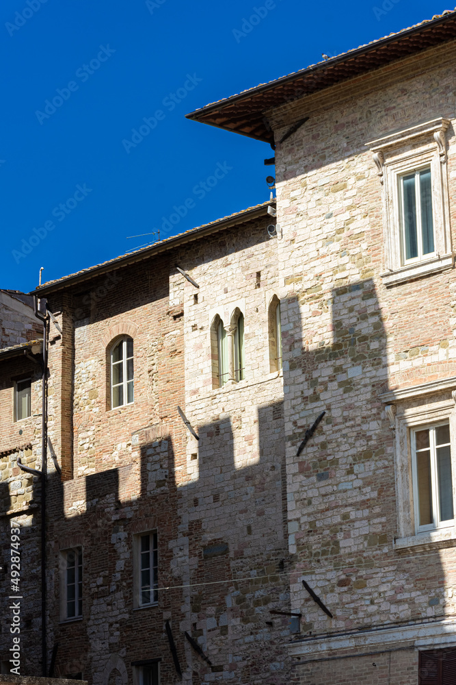 Shadow of Palazzo dei Priori on a medieval building in the historicc center of Perugia, Umbria Italy