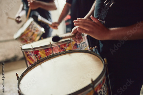 Sounds that come straight out of Brazil. Closeup shot of a musical performer playing drums with his band.