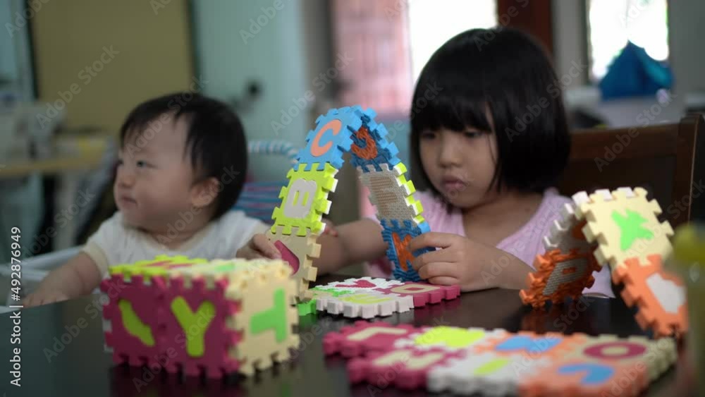 Selective focus alphabet puzzle played by little daughter. Smart brain game of kid concept Selective focus alphabet puzzle played by little daughter. Smart brain game of kid concept