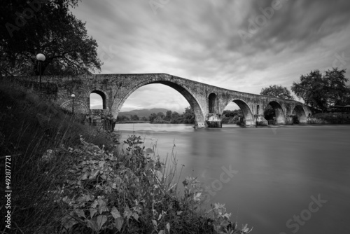 Stone arch bridge over river in Arta city, Greece. photo