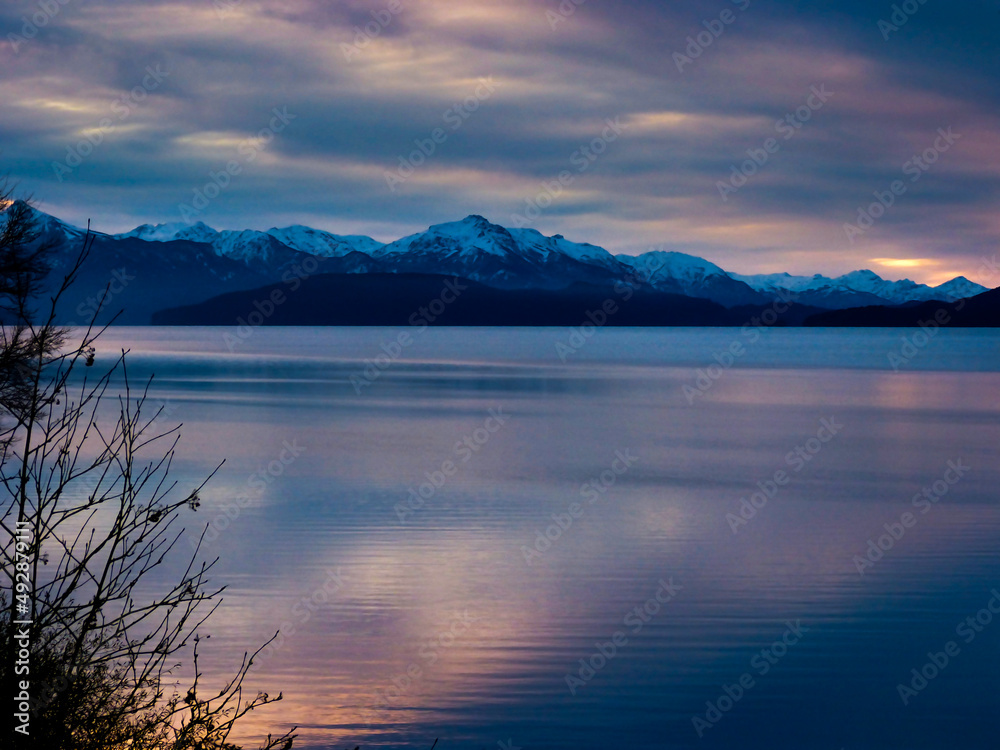 Lake landscape with mountains at sunset with clouds in the sky