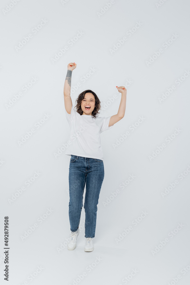 Excited brunette woman showing yes gesture on grey background. Excited brunette woman showing yes gesture on grey background.