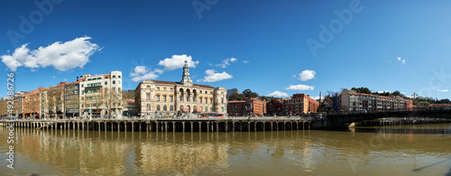 Panoramic view of the river in the city of Bilbao on a day with a blue sky and some white clouds.