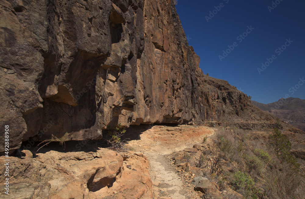 Gran Canaria, landscape of the southern part of the island along Barranco de Arguineguín steep and deep ravine
with vertical rock walls, circular hiking route starting at a hamlet Barranquillo Andres
Gran Canaria, landscape of the southern part of the island along Barranco de Arguineguín steep and deep ravine
with vertical rock walls, circular hiking route starting at a hamlet Barranquillo Andres