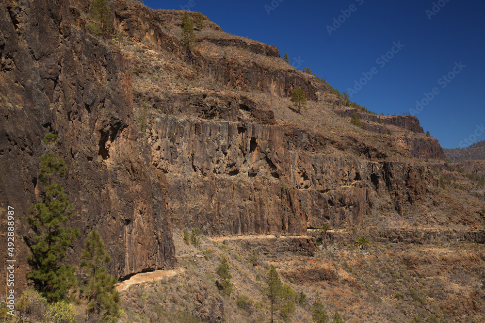 Fototapeta premium Gran Canaria, landscape of the southern part of the island along Barranco de Arguineguín steep and deep ravine with vertical rock walls, circular hiking route starting at a hamlet Barranquillo Andres 