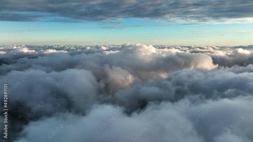 Top view of the clouds in the morning light. Aerial view of cumulus clouds. Sunlighten cumulus clouds under horizon. over the cumulus clouds in the morning. Top view of the clouds in the morning light. Aerial view of cumulus clouds. Sunlighten cumulus clouds under horizon. over the cumulus clouds in the morning.