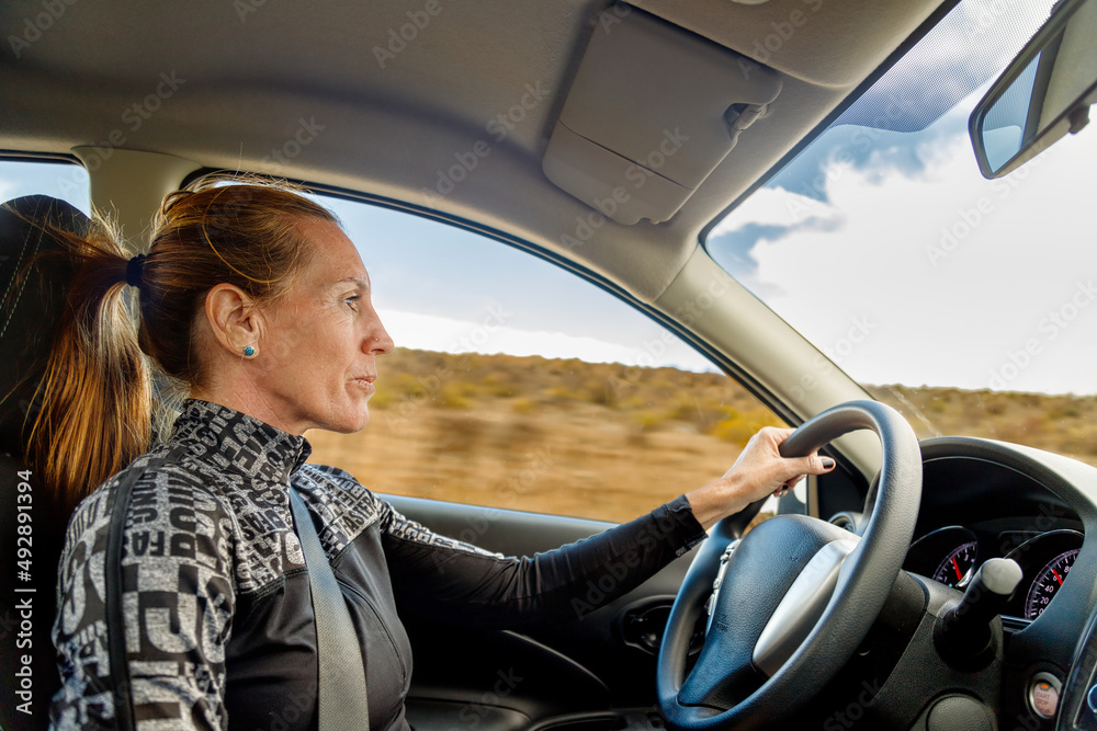Woman seen from the side driving a car at high speed Woman seen from the side driving a car at high speed