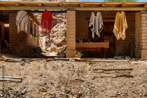 Characteristic ponchos from northern Argentina hanging in a rustic adobe store photo