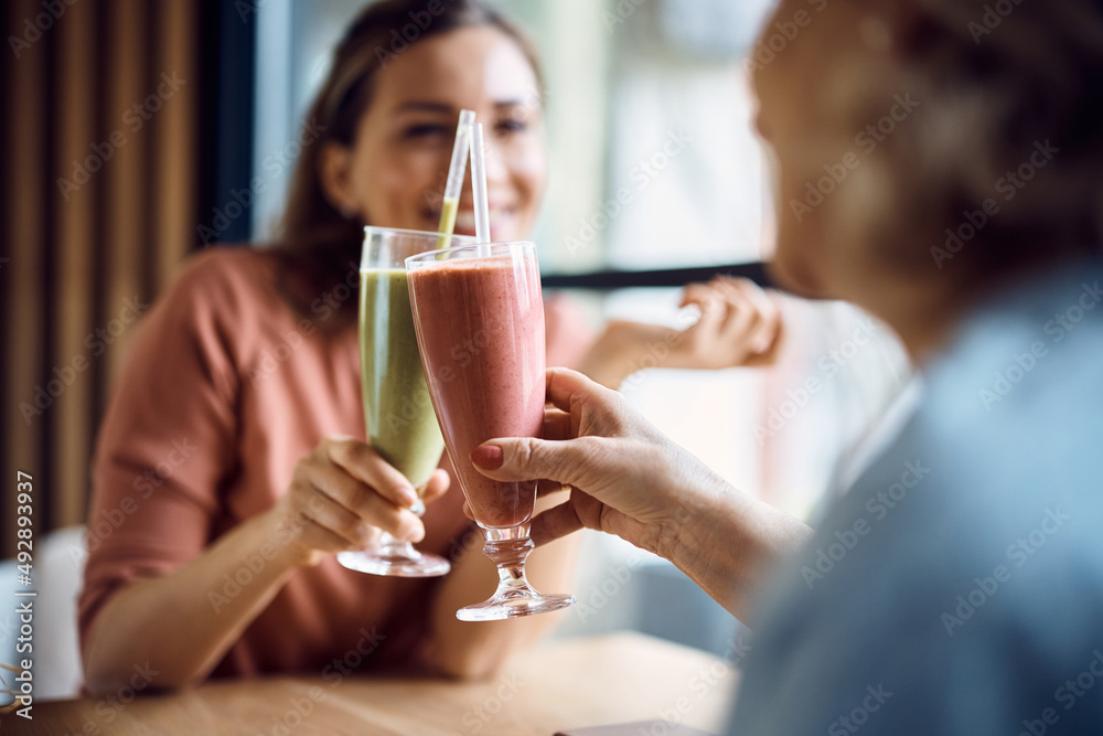 Close-up of mother and daughter toast with drinks in cafe. Close-up of mother and daughter toast with drinks in cafe.