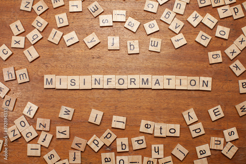 misinformation letters arranged on wooden board photo