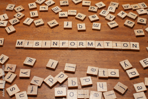 misinformation letters arranged on wooden board background photo