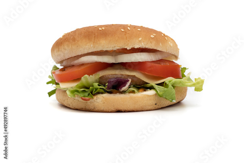 A hamburger, with the ingredients, lettuce, cabbage, cucumber, tomato, onion, cheese, ketchup, mayonnaise. Isolated on white background. One of the most consumed snacks in the world.