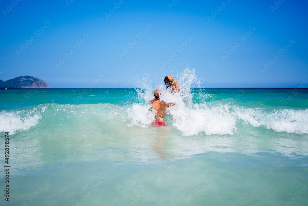 Man with daughter playing in sea Man with daughter playing in sea