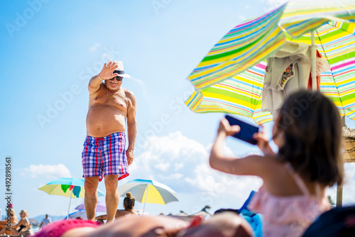 Girl taking photo of smiling grandfather photo