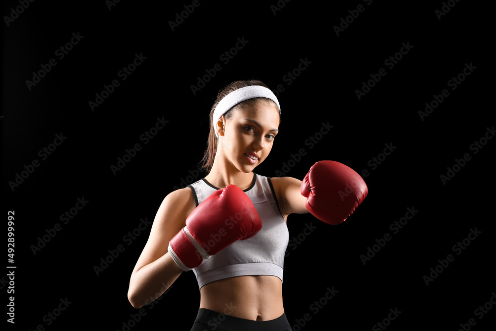 Sporty teenage girl with boxing gloves on black background Sporty teenage girl with boxing gloves on black background