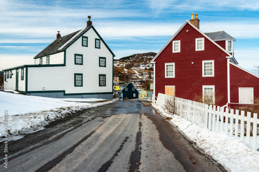 Trinity, Newfoundland, Canada - March 2022: A street view of historic Trinity with large wooden colorful houses. 19th century three storey buildings with single hung windows, dormers, and steep roofs. Trinity, Newfoundland, Canada - March 2022: A street view of historic Trinity with large wooden colorful houses. 19th century three storey buildings with single hung windows, dormers, and steep roofs.