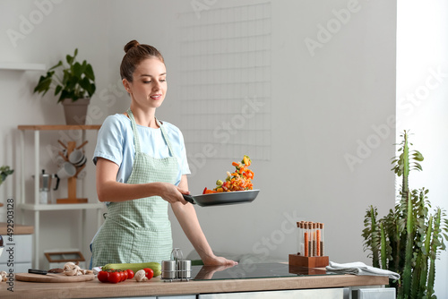 Beautiful housewife frying ...