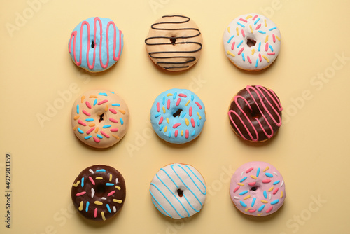 Different sweet donuts on color background