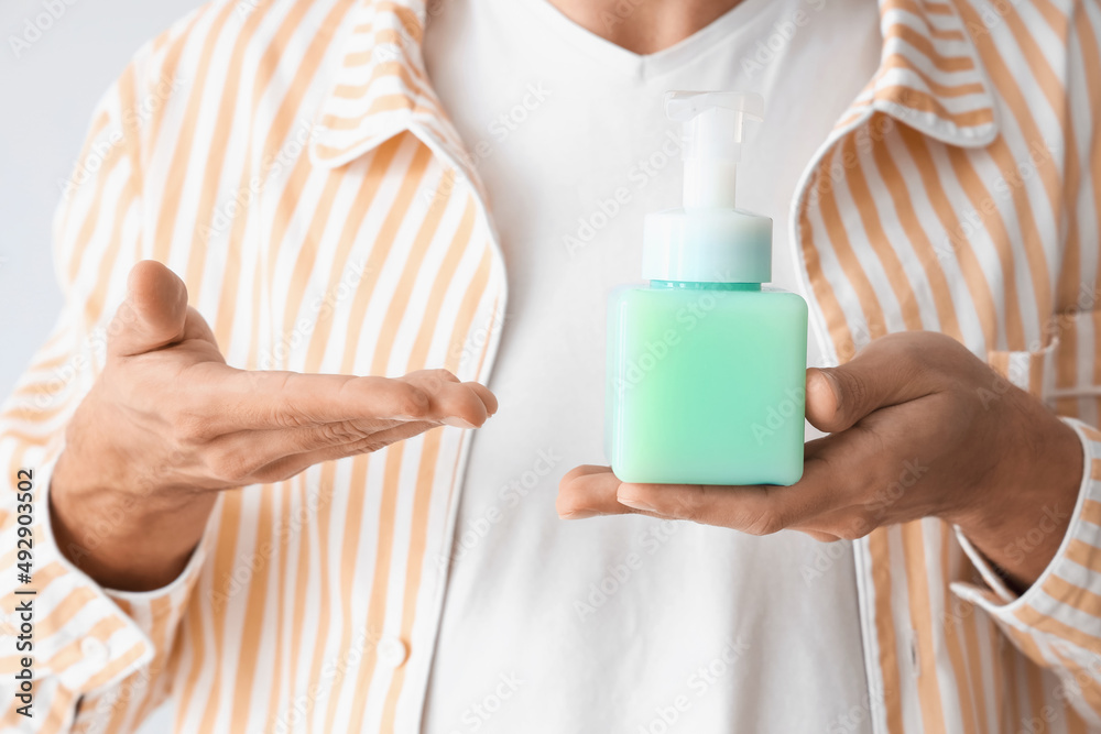 Young man with liquid soap, closeup Young man with liquid soap, closeup