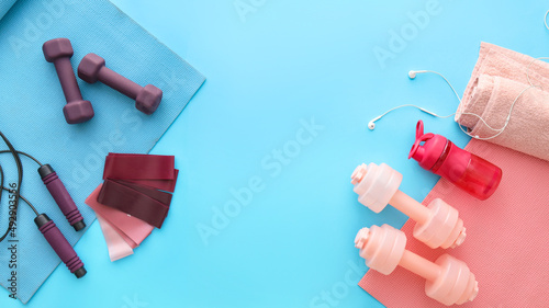 Different sports equipment and earphones on color background © Pixel-Shot