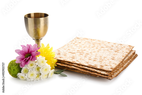 Jewish flatbread with goblet and flowers on white background photo