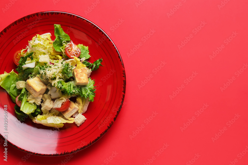 Plate with tasty vegan Caesar salad on red background - obrazy, fototapety, plakaty 