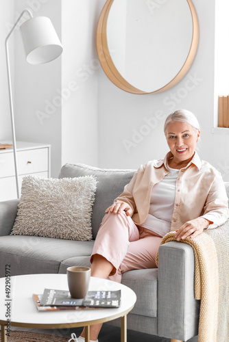 Mature woman sitting on sof...