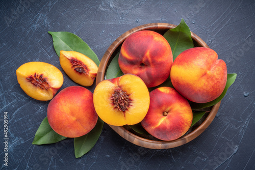 Fresh Yellow Peach fruit in wooden bowl on wooden background., Yellow Peach with slice in wooden basket, 