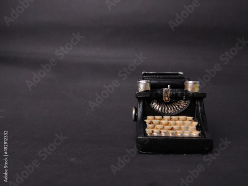 Vintage black typewriter on the black background, copy space for your text.