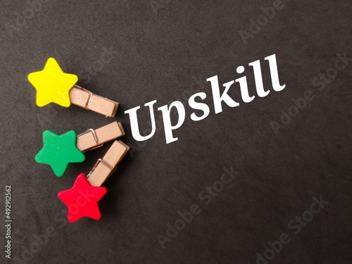 Top view colored wooden clips with text Upskill on black background.