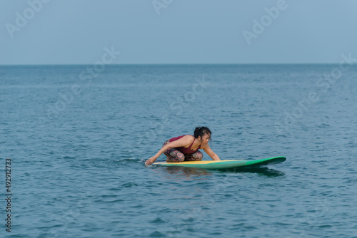 person on a sub-boad. person surfing on the waves. woman doing yoga. woman doing yoga exercise