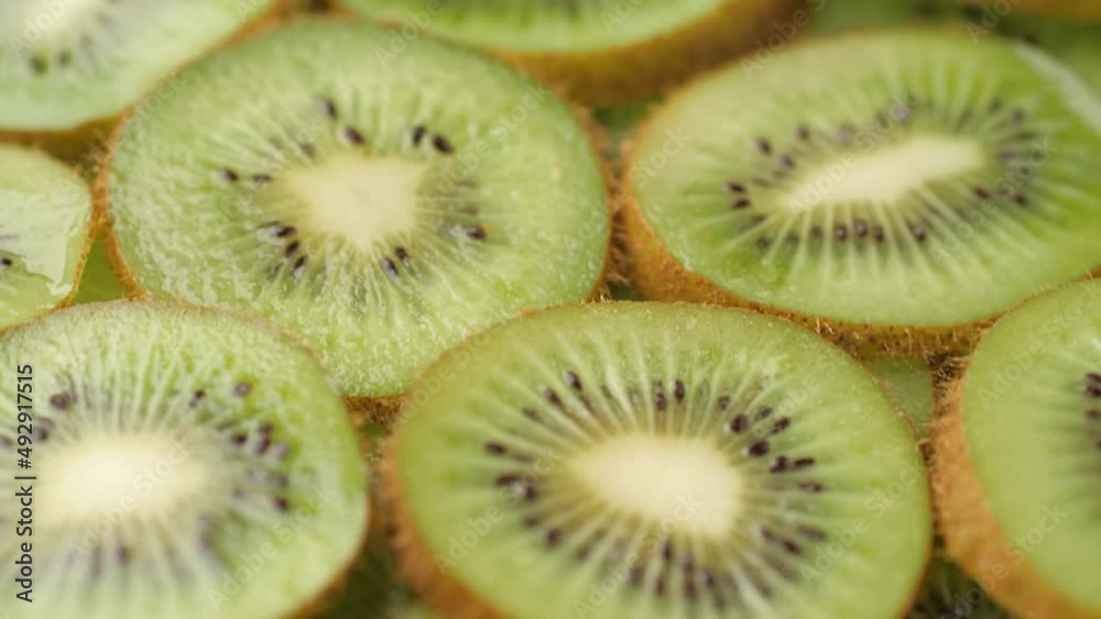 Kiwi fruit. Camera slowly moves up to show macro shot of fresh juicy sliced kiwi fruit Kiwi fruit. Camera slowly moves up to show macro shot of fresh juicy sliced kiwi fruit