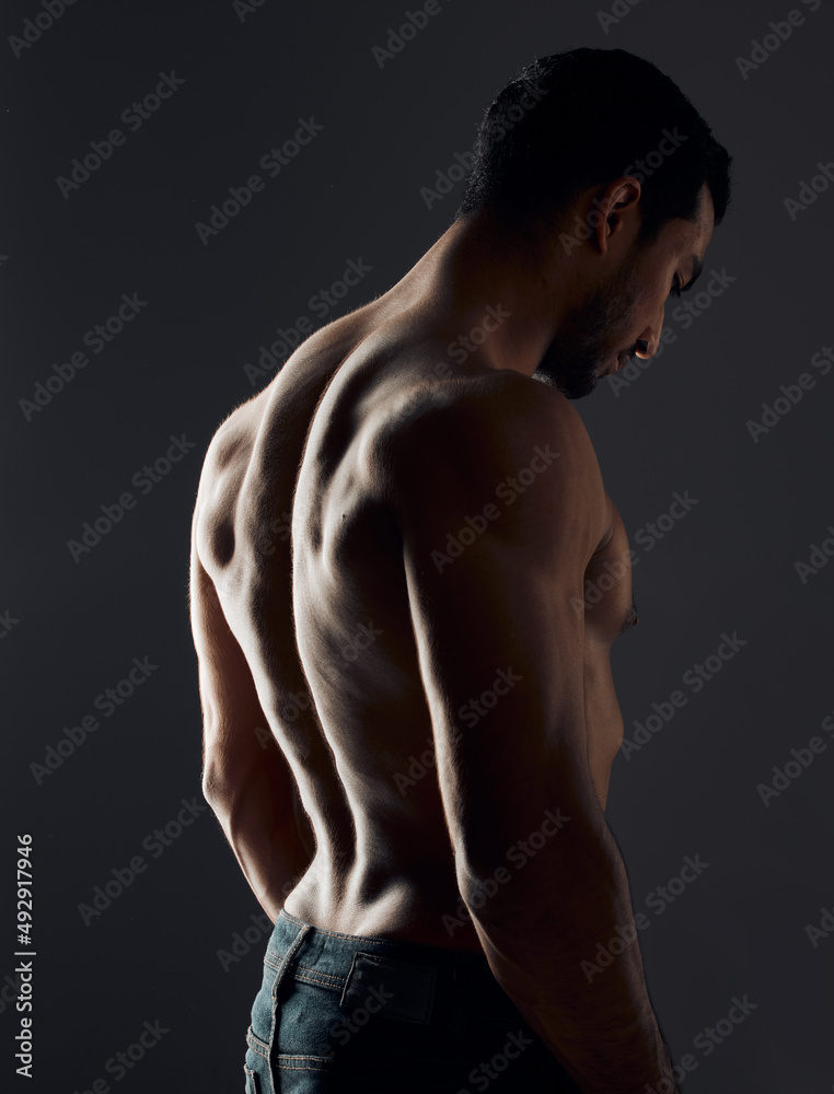 I work every muscle in the gym. Shot of a handsome young man standing alone and posing shirtless in the studio. I work every muscle in the gym. Shot of a handsome young man standing alone and posing shirtless in the studio.
