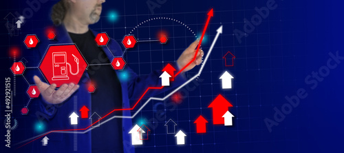 Businessman draw growth graph and hold petrol pump sign - fuel prices rising. Business planning and strategy. Rise of oil and gas on stock markets. Background with place for text.