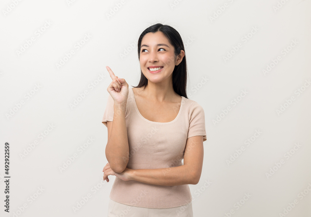 Beautiful asian woman pointing finger into blank space. Smiling female standing pose on isolated white background. Attractive Teenager girl around 25 looking at empty space for advertise text. Beautiful asian woman pointing finger into blank space. Smiling female standing pose on isolated white background. Attractive Teenager girl around 25 looking at empty space for advertise text.